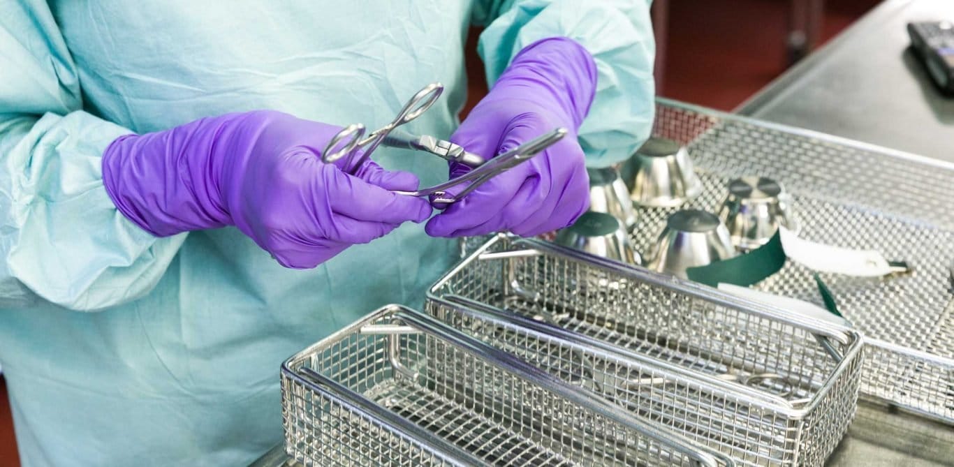 Die Sterilisationsassistentin sortiert die OP-Instrumente.