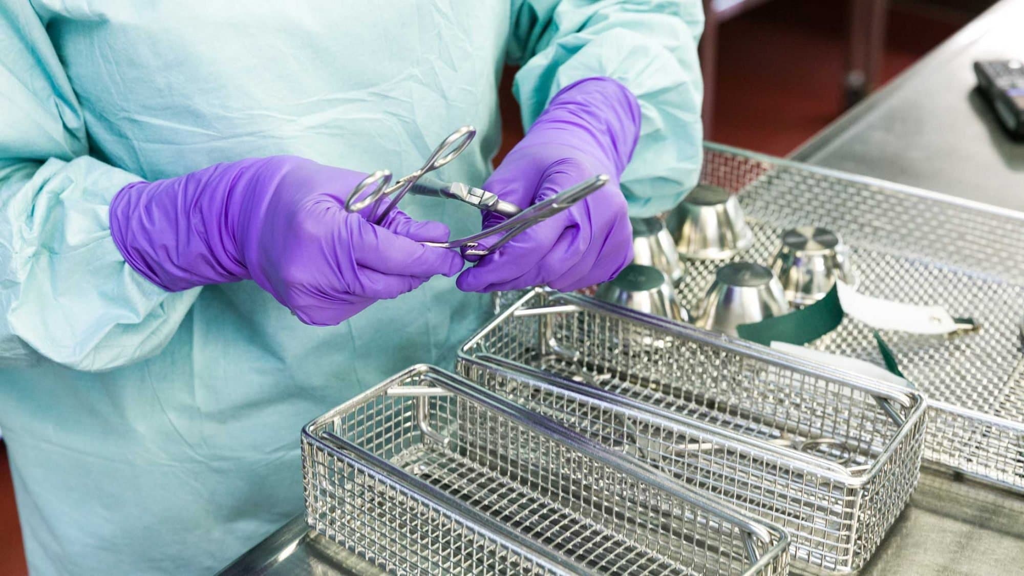 Die Sterilisationsassistentin sortiert die OP-Instrumente.