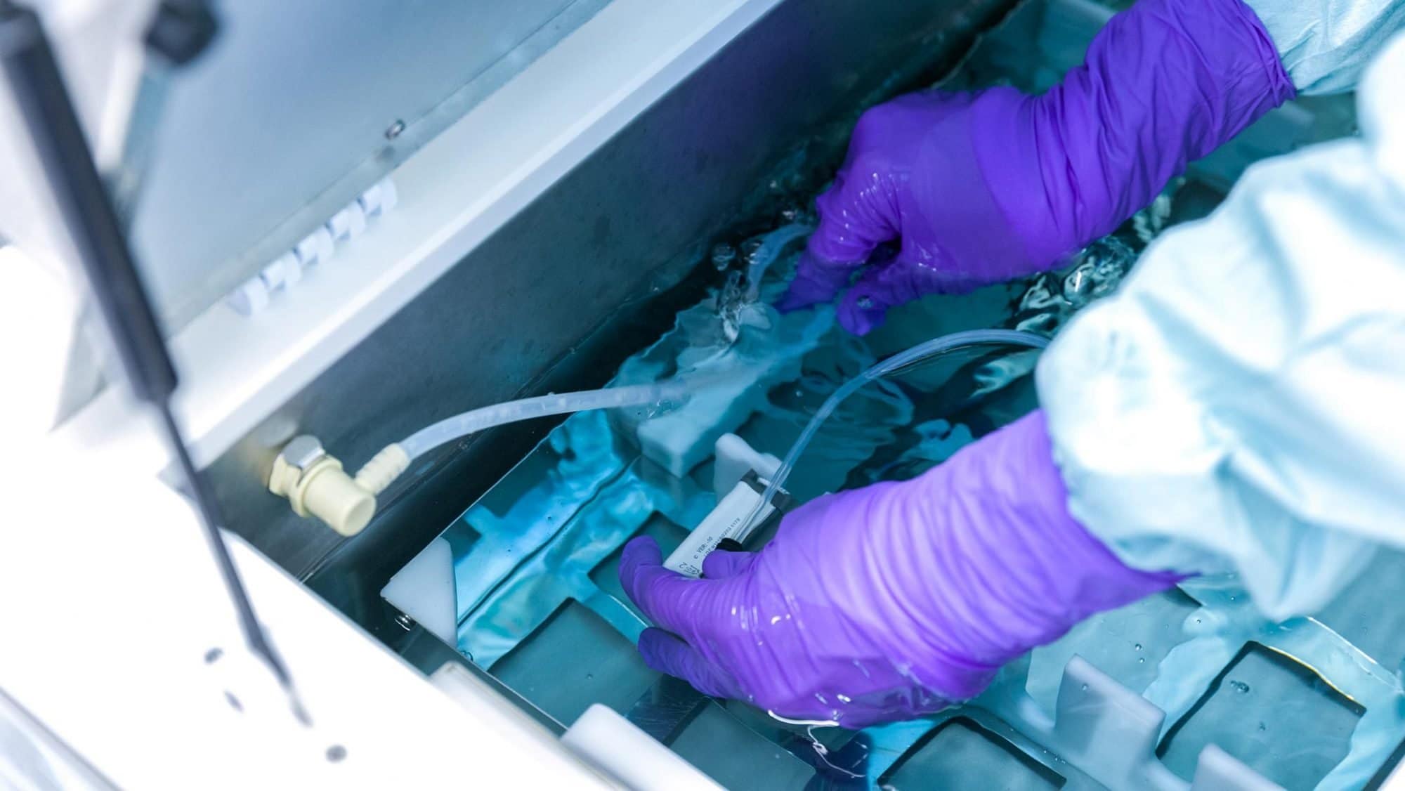 Die Sterilisationsassistentin legt die Instrumente in einen mit Wasser gefüllten Behälter.