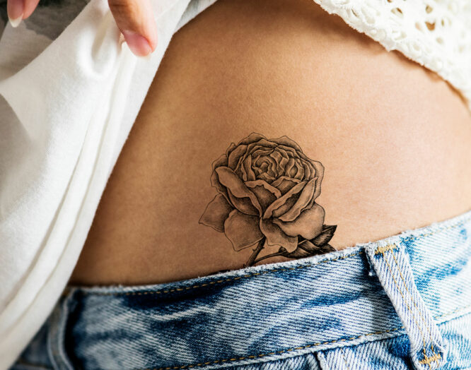 Gürtelrose: Tätowierung einer Rose auf dem Bauch einer jungen Frau