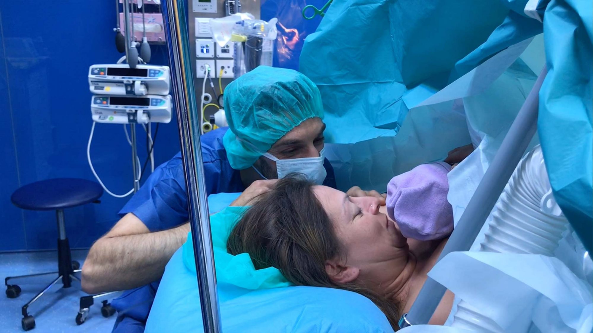 Eine Patientin hält nach dem Kaiserschnitt ihr Baby in einem Bondingtuch.