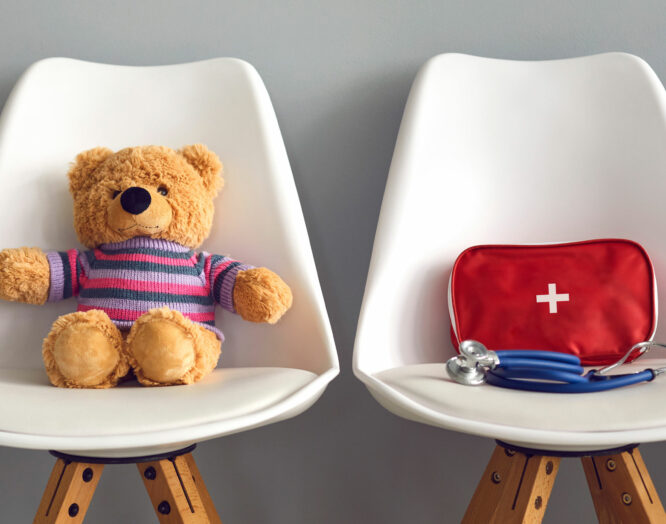 Kinderarzt finden: Teddybär und Notapotheke auf Stühlen