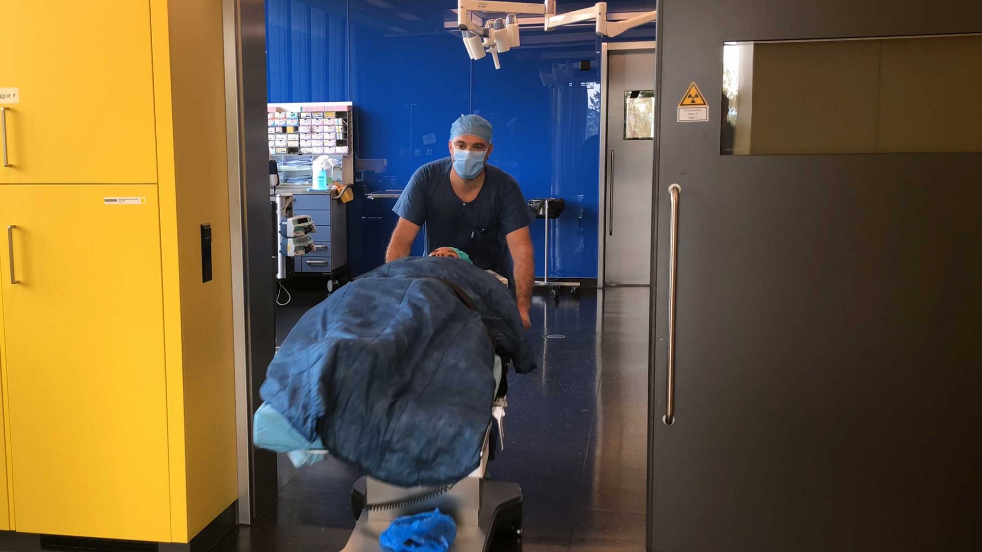 Ein Patient wird aus dem ambulanten Operationssaal in den Aufwachraum geschoben.