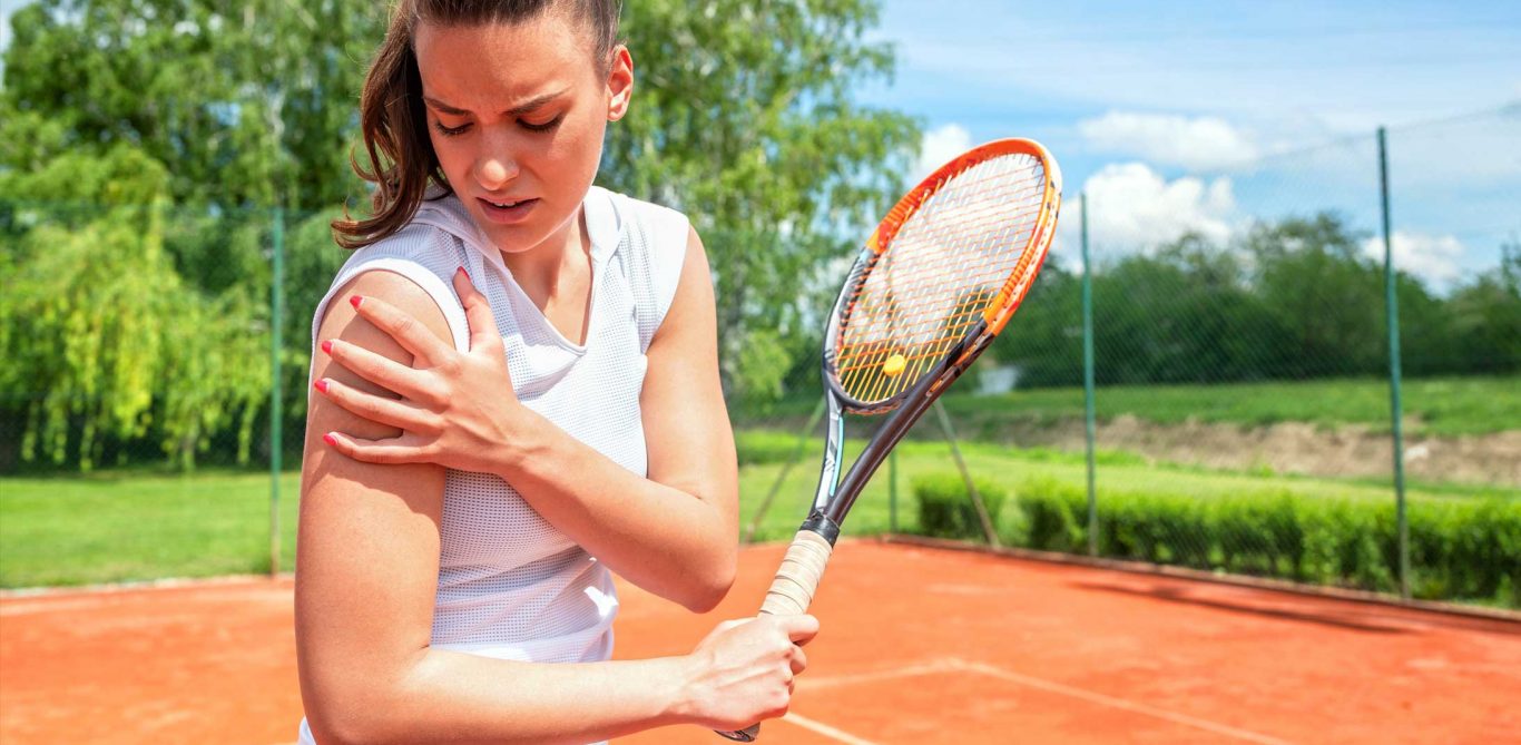 Frau die Tennis spielt hält sich die Schmerzende Schulter