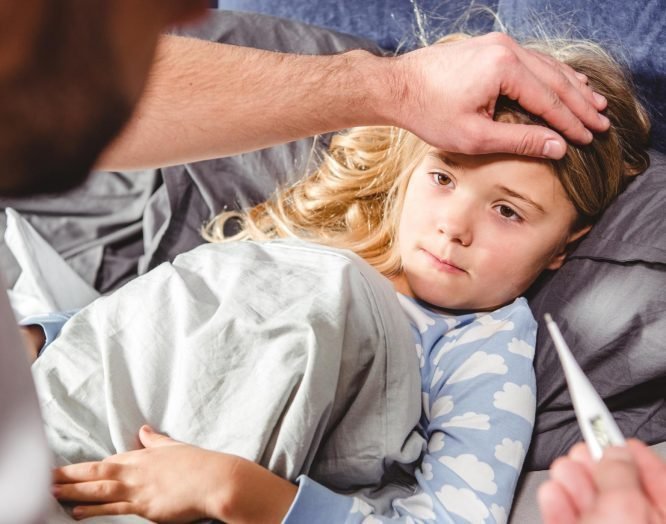 Ein Kind mit Fieber und Mittelohrentzündung im Bett