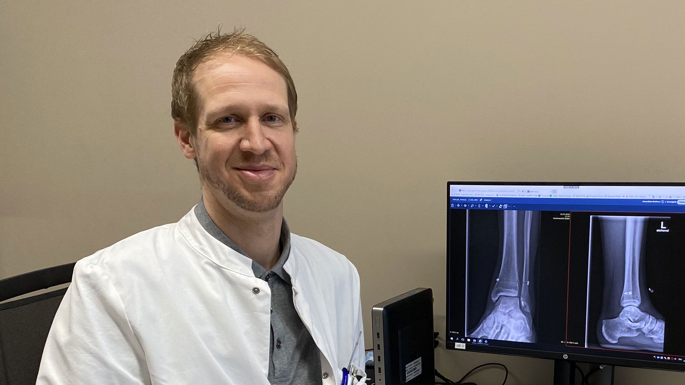 KSB-Fusschirurg Christopher Lenz sitzt am Arbeitsplatz vor einem Bildschirm mit Röntgenaufnahme.