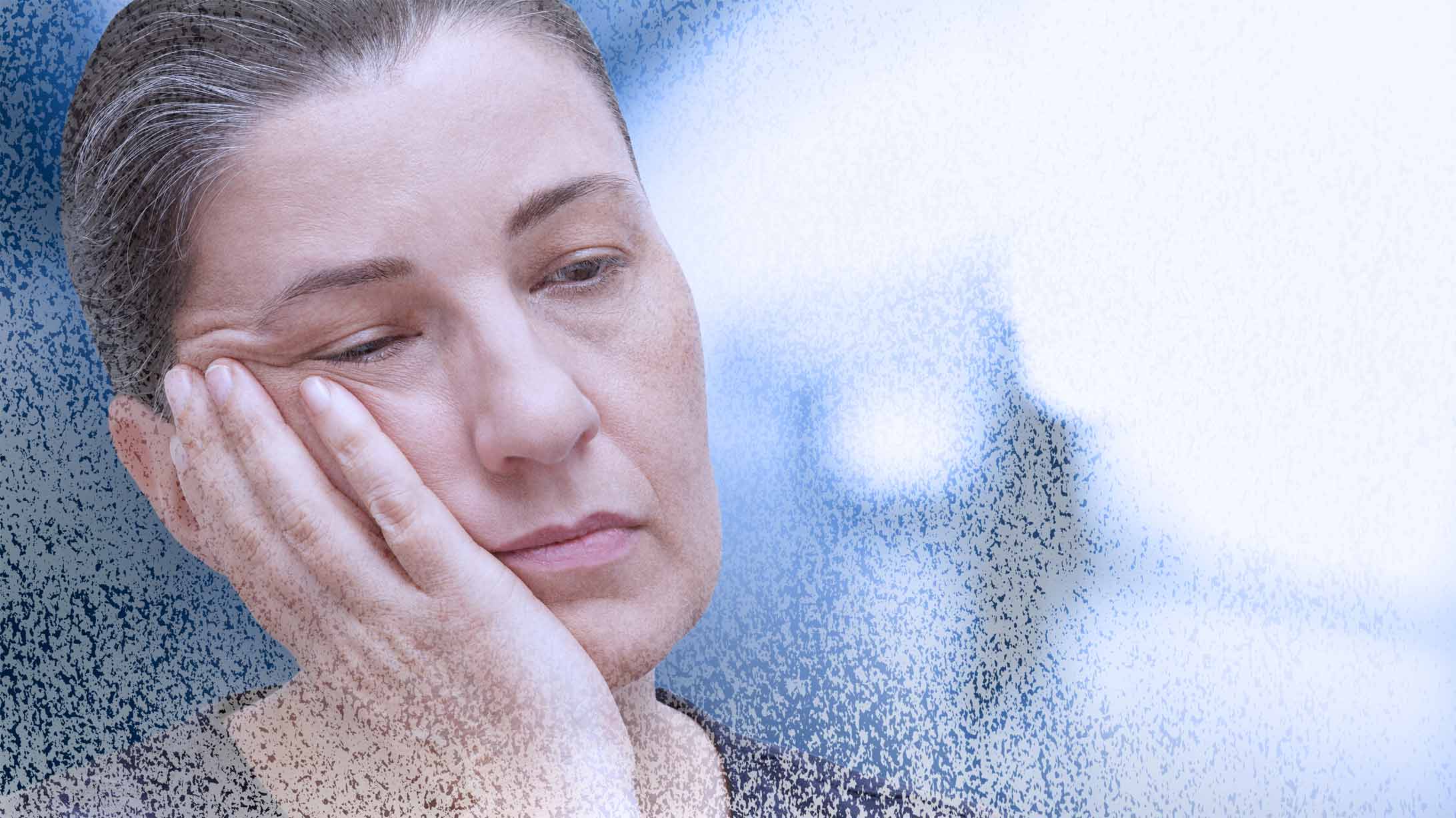Krebsfatigue: Frau mit geschlossenen Augen stützt den Kopf in die Hand