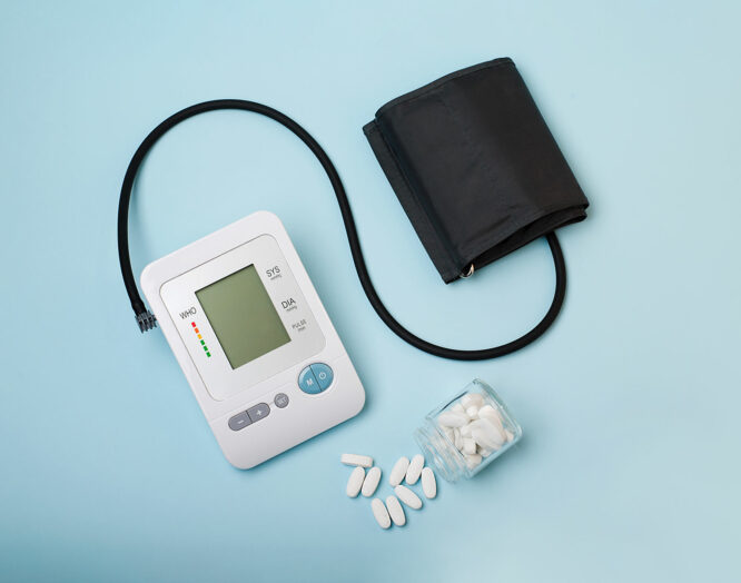 Bluthochdruck: Themenbild mit Blutdruckmessgerät und Tabletten